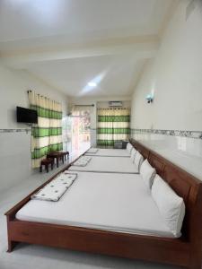 um quarto com uma fila de camas em Motel Tiến Phúc em Long Hai