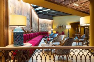 グラナダにあるホテル パラシオ デ サンタ パウラ オートグラフ コレクションの赤いソファと椅子付きのロビー