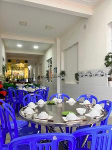 ein Esszimmer mit blauen Stühlen und einem Tisch in der Unterkunft Motel Tiến Phúc in Long Hải