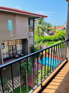 Elle dispose d'un balcon offrant une vue sur une maison dotée d'une piscine. dans l'établissement The Cave, à Negombo