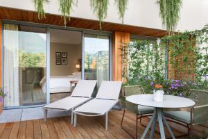 un patio con sillas blancas y una mesa en Sheraton Lake Como Hotel, en Como
