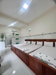 two beds in a large room with a kitchen at Motel Tiến Phúc in Long Hai