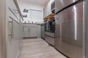 a kitchen with a refrigerator and a sink at Brand New Luxury Apt! Heart of Montrose- Downtown HTX in Houston