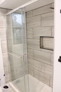 a shower with a glass door in a bathroom at Luxury Home near Notre Dame with Arcade Room in South Bend +38 photos