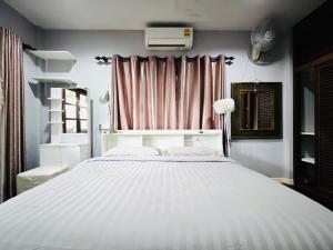 Una cama blanca grande en una habitación con ventana. en PM Hill villa, en Bophut  11 fotos más