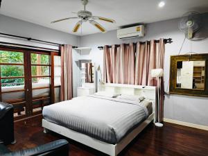 Un dormitorio con una cama y un ventilador de techo. en PM Hill villa, en Bophut 
