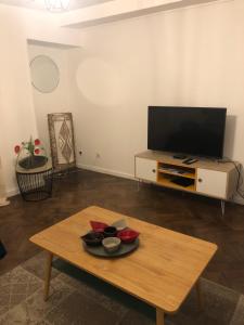 sala de estar con mesa de centro y TV de pantalla plana en LA FINNOISE, en Fains-les-Sources