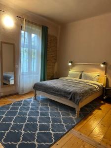 1 dormitorio con cama y ventana grande en World Studio Family Apartment, en Sibiu