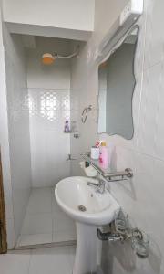 a white bathroom with a sink and a mirror at Cozy Homestays Meru in Meru