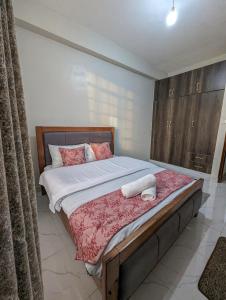 a bedroom with a bed with two towels on it at Cozy Homestays Meru in Meru
