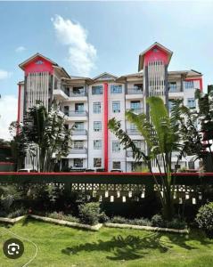 a large white building with red accents at Cozy Homestays Meru in Meru