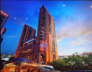 wysoki budynek z pociągiem przed nim w obiekcie Vacation Suites at Times Square KL w Kuala Lumpur