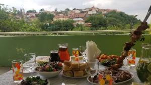 une table avec un bouquet de nourriture assise sur un balcon dans l'établissement Guest House Vista, à Sighnaghi