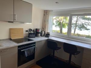 a kitchen with two chairs and a counter with a window at Dünenhaus 2 Schlafzimmer in Timmendorfer Strand +8 photos