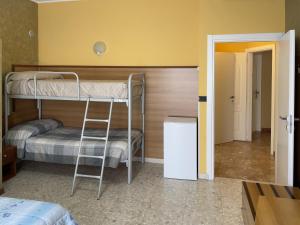 Zimmer mit 2 Etagenbetten und einem Kühlschrank in der Unterkunft La Lanterna in Silvi Marina