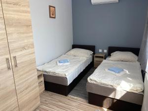 two beds in a small room with a closet at Aba - Böbe Vendégház in Zalaszentiván