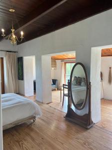 1 dormitorio con espejo grande y cama en Willdenowia Guestsuite at Waboom Family Farm, en Stanford