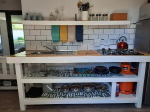a kitchen counter with a sink and a stove at 23 Belladonna Cottage in Hermanus