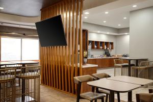a restaurant with wooden walls and tables and chairs at SpringHill Suites by Marriott Tulsa in Tulsa