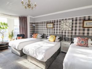 a bedroom with two beds and a clock on the wall at Seaview Wellness Retreat in Carnoustie