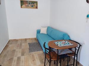 a living room with a blue couch and a table at Hari Apartments Vathi, Agios Nikolaos Crete in Vathi
