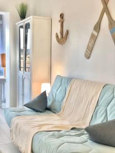 a living room with a couch and a cross on the wall at Le Brusc. Design, Parking, Wifi & Double Vue! in Six-Fours-les-Plages
