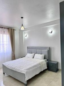 una camera bianca con un grande letto e una finestra di B&B Homes sleep over a Kampala