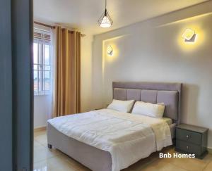 una camera da letto con un grande letto con una grande finestra di B&B Homes sleep over a Kampala