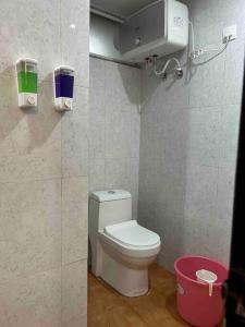 een kleine badkamer met een toilet en een emmer bij The velvet studio 203 in Dehradun