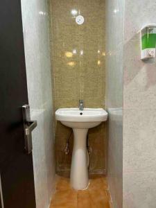 een badkamer met een witte wastafel en een toilet bij The velvet studio 203 in Dehradun