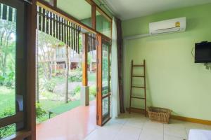 an empty room with a ladder and a window at AuangKham Resort in Lampang