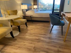 a bedroom with a bed and a table and chairs at Das Hotel Ostseeblick in Lütjenburg