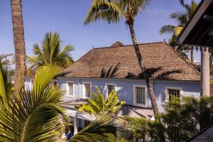 聖吉爾萊班的住宿－布康格努酒店，一座棕榈树掩映的白色房子