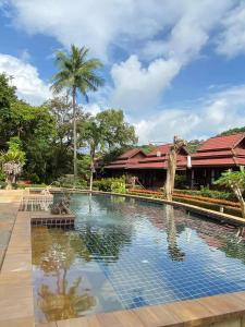 a swimming pool in front of a resort at Baan Laanta Resort & Spa - SHA PLUS in Ko Lanta
