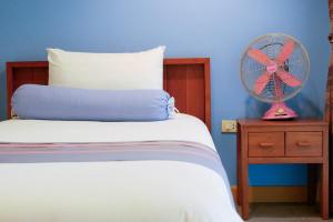 a bedroom with a bed and a fan on a nightstand at AuangKham Resort in Lampang