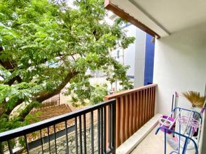 - un balcon avec deux chaises et un arbre dans l'établissement The Urban Pattaya, à Pattaya