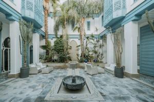 un patio con una fuente en el medio de un edificio en Riad Le Perroquet Bleu Suites & Spa, en Marrakech