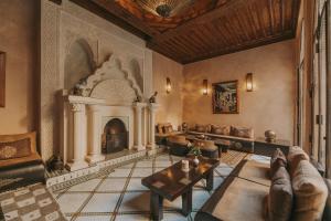 a living room with a fireplace and a table at Riad Le Perroquet Bleu Suites & Spa in Marrakesh
