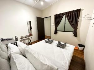 ein Wohnzimmer mit einem weißen Bett und einem Sofa in der Unterkunft Madras Inn 58-1 in George Town
