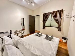 ein Wohnzimmer mit einem weißen Bett und einem Sofa in der Unterkunft Madras Inn 58-1 in George Town