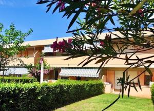 a building with pink flowers in front of it at IssTravel, Holiday Homes in Marina di Bibbona from 400 to 900 meters from the sea, apartments 6 beds with private outdoor area in Marina di Bibbona