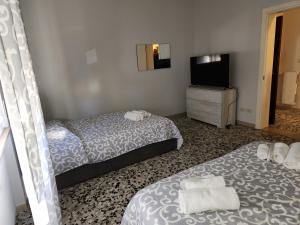 Habitación de hotel con 2 camas y TV de pantalla plana. en NIKI HOME, en Podenzano
