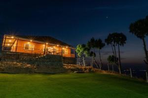 a house sitting on top of a green at night at Summit View 3bhk by Roamhome in Bhikia Sain