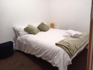 białe łóżko z poduszkami i ręcznikami w obiekcie Hallam Homestyle relocators and contractors w mieście Walkly