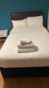 uma cama com duas toalhas em cima em IServe em Parkside