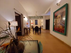 uma sala de estar com uma grande pintura na parede em Kariappa House em Pondicherry
