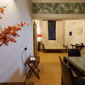 uma sala de estar com uma mesa e cadeiras e uma janela em Kariappa House em Pondicherry