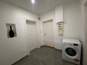 - une buanderie avec un lave-linge et une porte dans l'établissement Le confort d'un appartement, à Schiltigheim