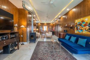 a living room with a blue couch and a tv at Summit View 3bhk by Roamhome in Bhikia Sain