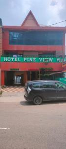 een auto geparkeerd voor een hotelingang bij hotel pine view in Dagshai